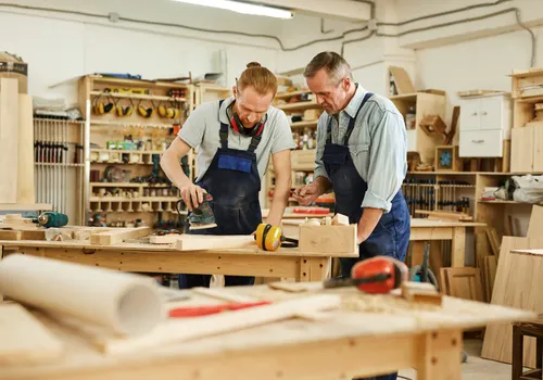 Fyzapew woodworking workshop with skilled artisans crafting handmade tree-inspired wooden bookshelves from solid natural wood